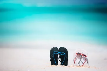 Poster Summer flip flops with sunglasses on white beach. Closeup beach accessories. © Tudoroniu