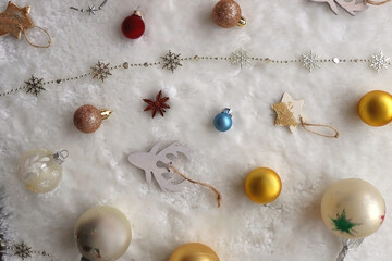 Various colorful Christmas oranments and white faux fur blanket. Top view.