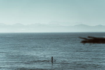 Mann auf dem Stand up Paddle Board auf dem Meer bei leichten Wellen 