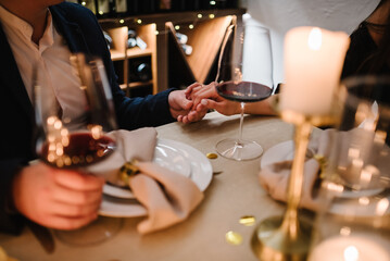 Romantic date by candlelight at night. Proposal hand and heart. Hands man and woman hold glasses. Couple in love drinking wine. Dinner setup table for couple. Will you marry me. She said yes. Top view