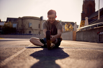 Smiling man with a prosthetic running blade stretching on a track