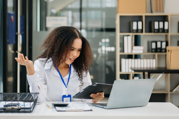 Confident business expert attractive smiling young woman typing laptop and holding digital tablet