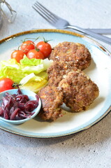 Meatballs with salad and cherry tomatoes on a plate. Selective focus.
