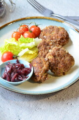 Meatballs with salad and cherry tomatoes on a plate. Selective focus.