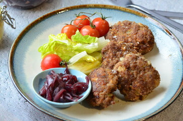 Meatballs with salad and cherry tomatoes on a plate. Selective focus.