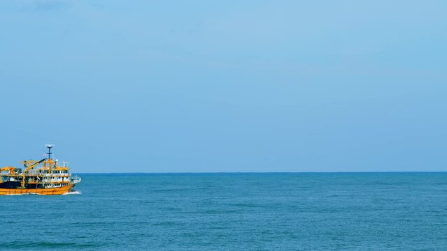 Fishing Boat Sailing .Ship Floats On Sea Surface With Blue Sky Leaving Path Sea Foam Water. Real time.