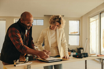 Home renovation professional signing a contract with a homeowner - obrazy, fototapety, plakaty