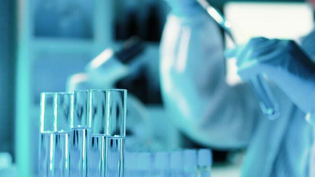 Lab assistant, a medical scientist, a chemistry researcher holds a glass tube through the blood sample, does a chemical experiment and examines a patient's blood sample. Medicine and research concept.