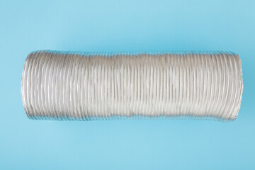New corrugated aluminium pipe on light blue table background. Ventilation part for kitchen cooker...
