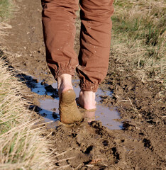 Walking in nature barefoot in the mud - 704892060