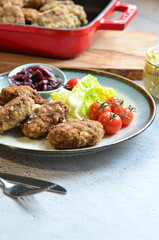 Meatballs with salad and cherry tomatoes on a plate. Selective focus.