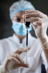 woman doctor on nurse in full medical uniform prepare syringe with medication for vaccine isolated