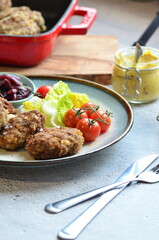 Meatballs with salad and cherry tomatoes on a plate. Selective focus.