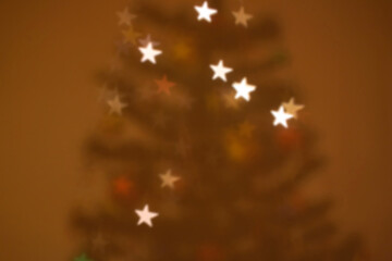 Decorated Christmas tree with star shaped bokeh lights. Defocused Christmas background.