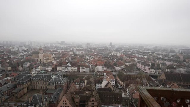 A panoramic view of Strasbourg city in France from the vantage point of the Strasbourg Cathedral. The rooftops and cityscape paint a captivating picture, with pigeon bird flying over across the scene.