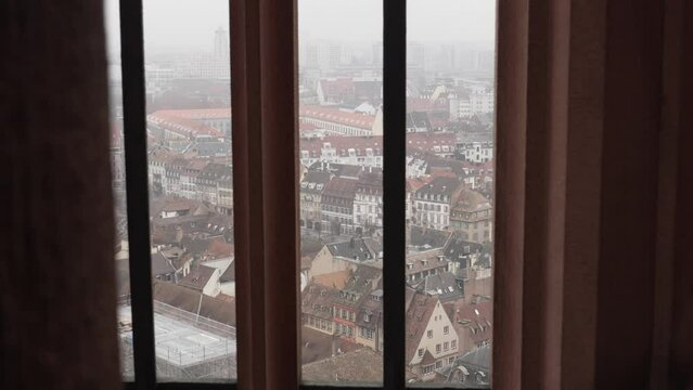 View from the Strasbourg Cathedral, glimpsing onto charming streets and rooftops of Strasbourg, with culture and architecture blending German and French influences. Panoramic shoot through window.