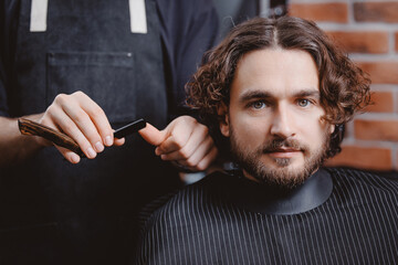 Barber shop, warm toning photo. Process shaving razor bearded hipster man in barbershop