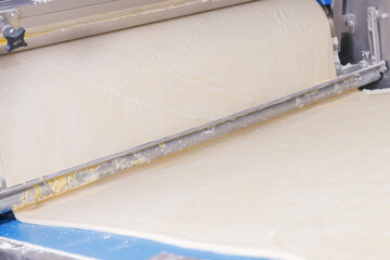 Automatic dough robot making puff pastry for production French croissants on line conveyor. Modern bakery smart food industry