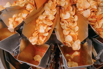 Foto op Aluminium Potato chips production line at food industrial plant. Filling machines for snacks, top view © Parilov