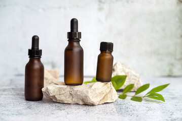 Amber Glass bottle with dropper lid  with cosmetic product serum on stone. Beauty concept