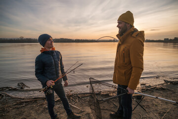 Father and son are ready for fishing on winter day. Freshwater fishing. - obrazy, fototapety, plakaty