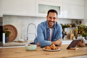 Portrait of a smiling man for a personal home cooking show while leaning on a kitchen counter.