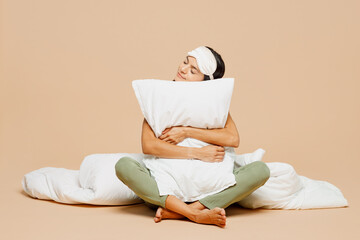 Full body young smiling calm Latin woman wears pyjamas jam sleep eye mask rest relax at home...