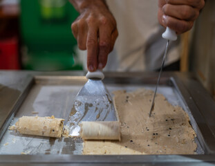 Artisan Crafting Rolled Ice Cream on a Hot Plate Indoors