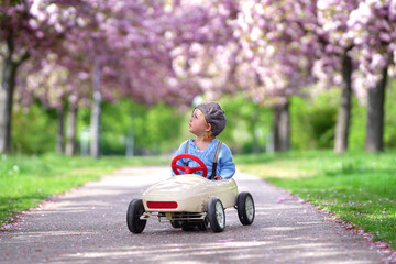 Kind fährt durch den blühenden Park