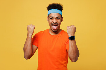 Young fitness trainer instructor sporty man sportsman wear orange t-shirt use smart watch do winner...