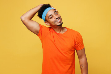 Young fitness trainer instructor sporty man sportsman wear orange t-shirt tilting hold his head...