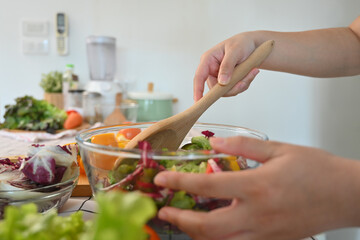 Senior woman preparing a healthy salad with organic vegetables. Healthy eating concept