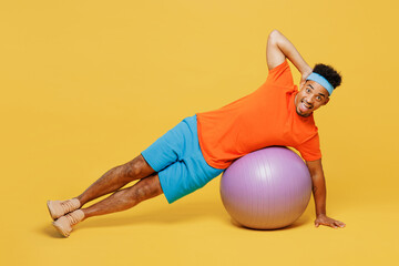 Full body young happy fitness trainer sporty man sportsman wear orange t-shirt do side plank...