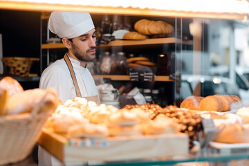 Meisterliche Präsentation: Der Bäcker arrangiert handgefertigte Köstlichkeiten für den Verkauf in seiner traditionellen Backstube