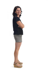 side view of a woman with shorts looking at camera and arms arms crossed on white background