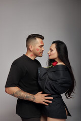 Kisses and hugs of couple in love, lovers. Passionate kisses on man face. Woman with rose flower in her husband hands