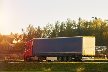 Modern white trucks with semi-trailers drive on a highway. Transporting cargo containers for...