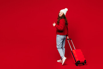 Side view traveler woman wear sweater hat casual clothes hold bag show thumb up isolated on plain...