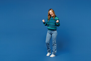 Full body young woman she wears knitted sweater casual clothes doing winner gesture celebrate...