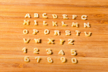 Pasta in alphabet letters and numerals shape on cutting board