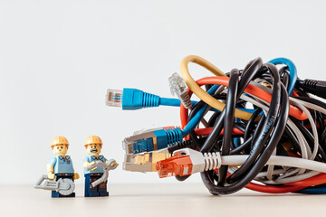 Naklejka premium Confused technicians and a tangled bunch of network cables. Illustrative editorial. Illustrative editorial