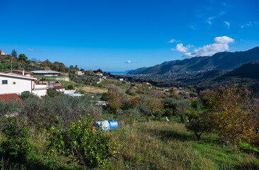 Fototapeta na wymiar Panoramic view over the rough mountains with houses and blue sky around Monreale, Italy