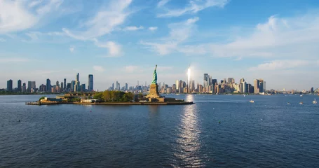 Glasschilderij Vrijheidsbeeld Aerial Helicopter Cinematic Passing View of the Statue of Liberty with Manhattan Skyline Cityscape. Panoramic View of New York City Skyscrapers and Jersey City Buildings on a Sunny Day