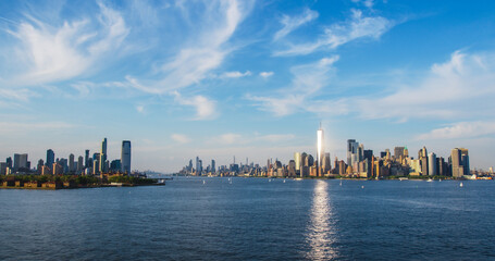 Obraz premium Aerial Photo with Manhattan Island with Office and Apartment Buildings. Hudson River Scenery with Yachts, Boats, and Sun Reflecting From the One World Trade Center Skyscraper