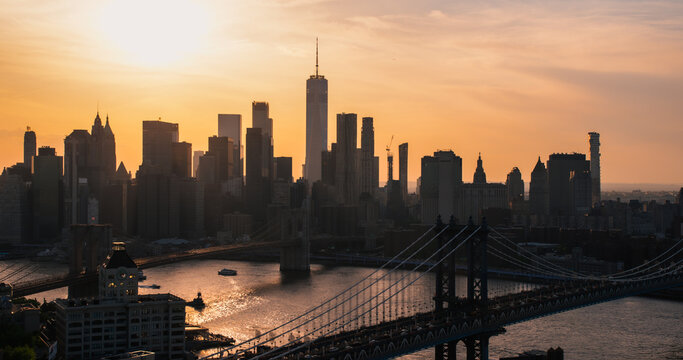New York City Skyline Aerial Photo from a Helicopter at Sunset. Famous Skyscraper Buildings with Manhattan and Brooklyn Bridges. Busy Diverse Megapolis with Cars, Boats and People Moving Around