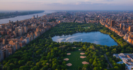 Helicopter Tour of New York City Architecture. Central Park Panoramic View of Office Buildings and Skyscrapers of Manhattan in a Warm Evening Sunlight