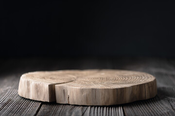 Wooden plate carved from tree trunk on old grunge wooden table on black background. Can be used...