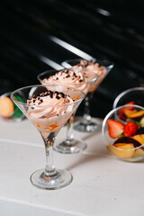 Swirled Peach Mousse with Chocolate Sprinkles in Martini Glasses. A delightful presentation of peach mousse with chocolate sprinkles served in elegant martini glasses, perfect for a chic dessert