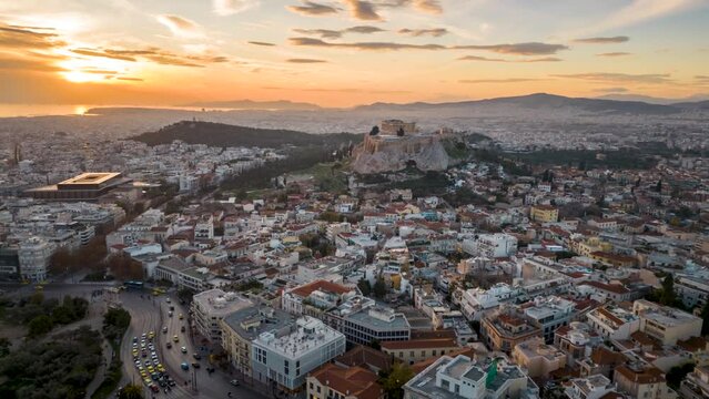 Aerial hyperlapse view of the urban skyline of Athens, Greece, with Acropolis and Temple of Olympian during sunset time