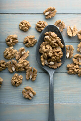 Walnut kernels in old spoon on wooden table close up. Food photography
